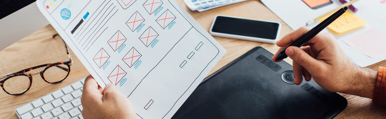 Cropped view of designer using graphics tablet while planning user experience design of website at...