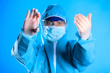 Coronavirus blood test concept. Doctor hands in medical gloves holding test tube with bloo
