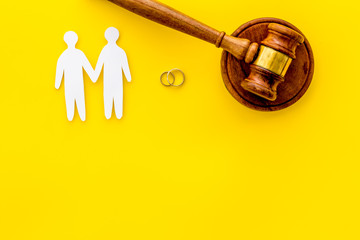 LGBT divorce. Judge gavel, rings, men gay couple on yellow background top-down copy space