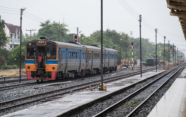Fototapeta na wymiar Diesel multiple units are leaving from the urban station in the rain time.