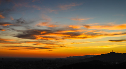 Fototapeta na wymiar Lindo por do sol com céu amarelo e laranja em um mirante na cidade de Barcelona, Espanha