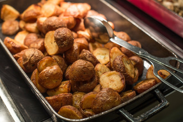 potatoes in a grill pan with tongs