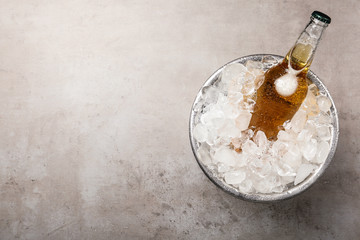 Beer in metal bucket with ice on grey table, top view. Space for text © New Africa