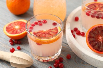 Lemonade, red orange and cranberry on wooden background, close up