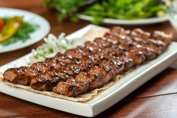 Fast food. Eastern food. Shish kebab, lyulya-kebab. Dishes of oriental cuisine lying in plte and...