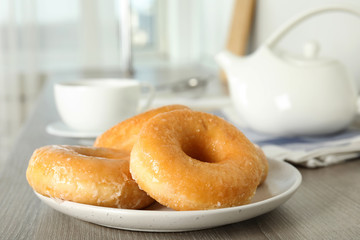Sweet delicious glazed donuts on wooden table