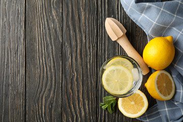 Glass with lemonade and ingredients on wooden background, top view