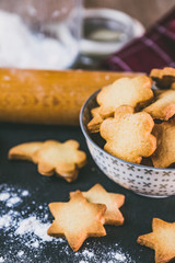 Biscuits sablés dans un bol, rouleau à patisserie farine et  forme en métal à découper