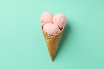 Ice cream in the cone on mint background, space for text