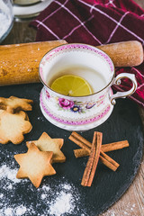 Thé au citron dans une tasse en porcelaine vintage et biscuits sablés à la cannelle