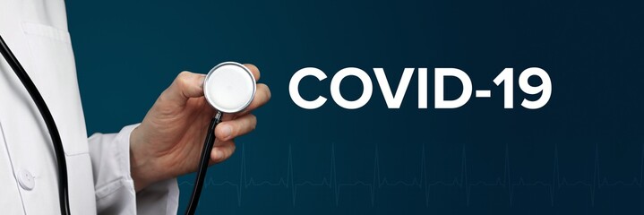 COVID-19. Arzt im Kittel hält Stethoskop. Das Wort COVID-19 steht daneben. Symbol für Medizin,...