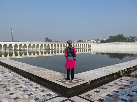 A Sikh Woman Standing Next To The Anandpur Sarovar In Anandpur Sahib, India