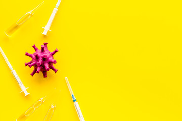 Corona virus Covid-19 - vaccine concept with syringe - on yellow background top-down frame copy...