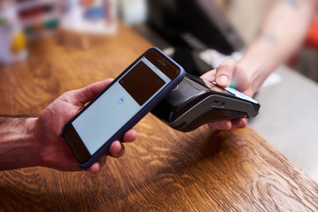 Customer paying by smartphone with NFC technology - Powered by Adobe