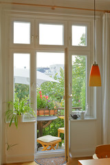 Balcony of an historic townhouse in summer, seen through the windows and door of the living room.