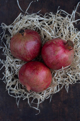 fresh ripe pomegranate on a dark wooden background garnet in the section. pomegranate