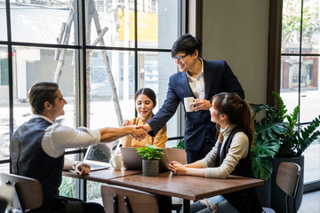 Handsome business man shaking hands with an attorney and an introduction team before interviewing in the office.
