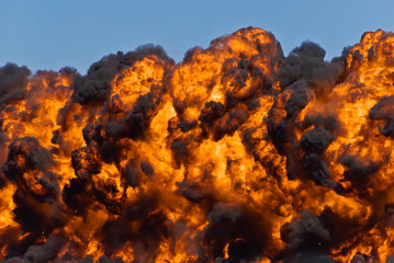 Firey explosion with thick black smoke on an airport runway.