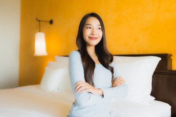 Portrait beautiful young asian woman happy smile relax on bed