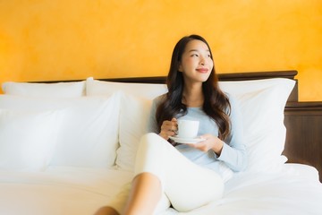 Portrait beautiful young asian woman with coffee cup on bed in bedroom