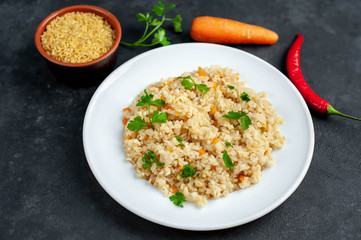 Bulgur with vegetables on a stone background. Healthy eating