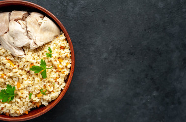 Bulgur with vegetables, chicken fillet on a stone background with copy space for your text. Healthy food