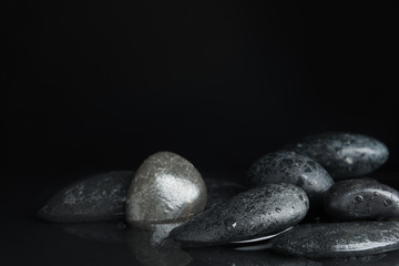 Stones in water on black background, space for text. Zen lifestyle
