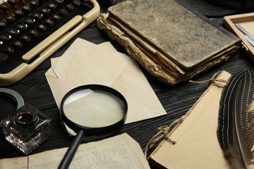 Composition with different vintage items on black wooden table. Detective's workplace