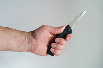 White Big male hand holding small sharp used knife