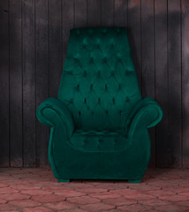 Fototapeta na wymiar green velvet armchair on a black background