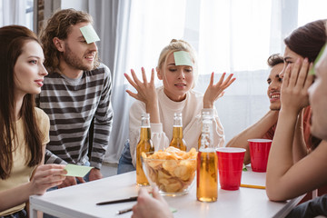 confused girl showing shrug gesture while playing name game with friends