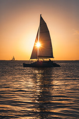 Fototapeta na wymiar croisière sur un coucher de soleil, catamaran