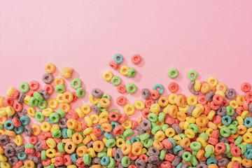 Fototapeta premium top view of bright multicolored breakfast cereal on pink background