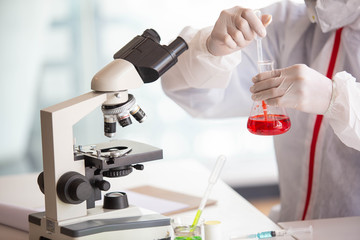 The doctor is testing a sample of biological tubes contaminated by Corona-virus Covid 19 and searching for a vaccine or Syrup against the virus. In the laboratory and film samples of infected lung