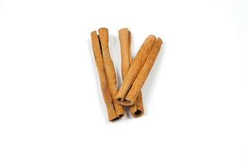 three cinnamon sticks , one on top of two, on a white background top view