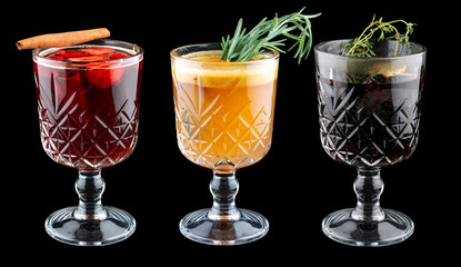 Hot drinks in glasses on a black background. Mulled wine and punch.