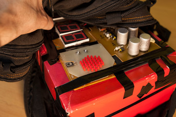 The terrorist puts a homemade bomb with a timer in a black bag.