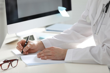 Doctor working at desk in office, closeup