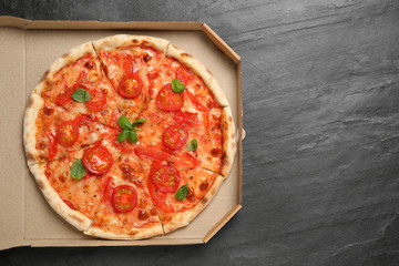 Delicious pizza Margherita on dark grey table, top view. Space for text