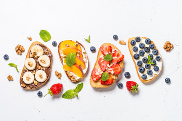 Sweet toast assortment with fresh fruit and berries on white.