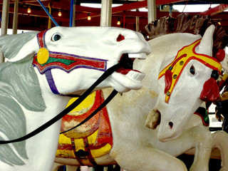 Closeup of hand-carved horses in action positions on a classic vintage carousel.
