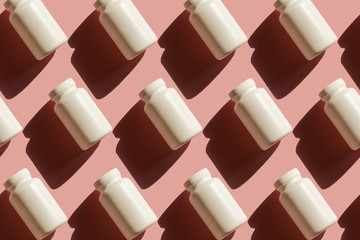 Repeating white cans of pills on a pink background, background in pop art style, medical concept
