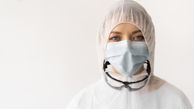 Laboratory Worker In A Specially Protected Suit And Glasses On A White Background.