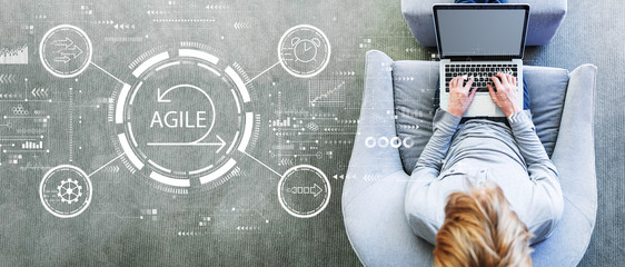 Agile concept with man using a laptop in a modern gray chair