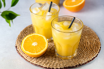 Tasty and Refreshing Orange Juice in Glass with Black Straws on Light Gray Background Fresh Ripe Oranges Above