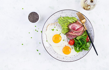 Ketogenic/paleo diet. Fried eggs, ham, avocado and fresh salad.  Keto breakfast. Brunch.  Top view, overhead