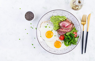 Ketogenic/paleo diet. Fried eggs, ham, avocado and fresh salad.  Keto breakfast. Brunch.  Top view, overhead