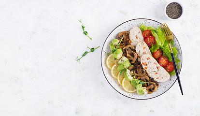 Trendy salad. Chicken meatloaf, fried mushrooms with salad fresh tomatoes and avocado. Healthy food, ketogenic diet, diet lunch concept. Keto/Paleo diet menu. Top view, overhead, flat lay