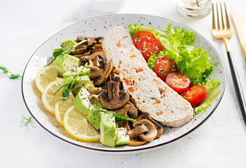 Trendy salad. Chicken meatloaf, fried mushrooms with salad fresh tomatoes and avocado. Healthy food, ketogenic diet, diet lunch concept. Keto/Paleo diet menu.