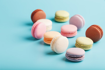 Multicolored French macaroni macaroni cookies on a blue background. Free space, top View.